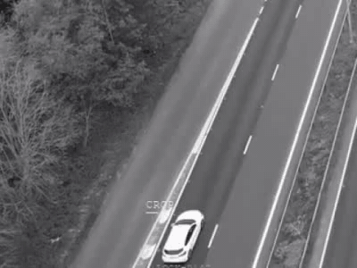 Operator crop drawing onto a white car on an aerial highway collect.